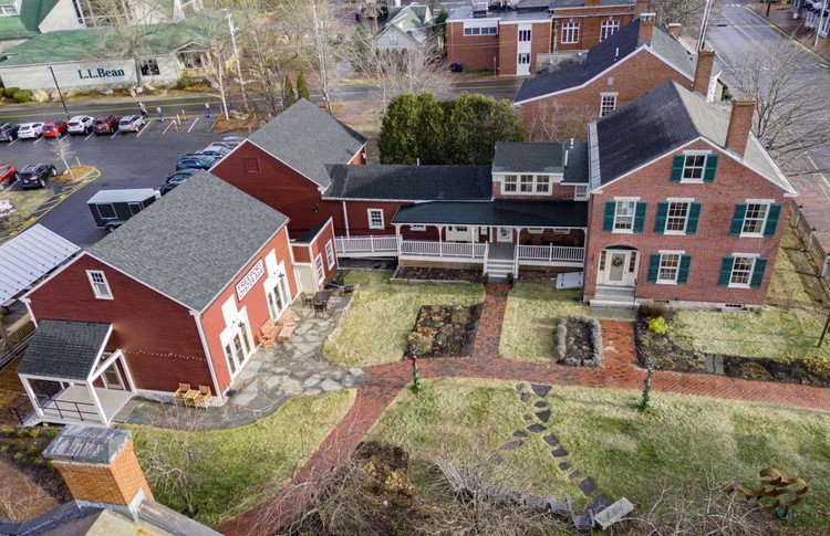 An aerial view of the Freeport Historical Society property, showing red buildings, connected structures, and brick pathways.
